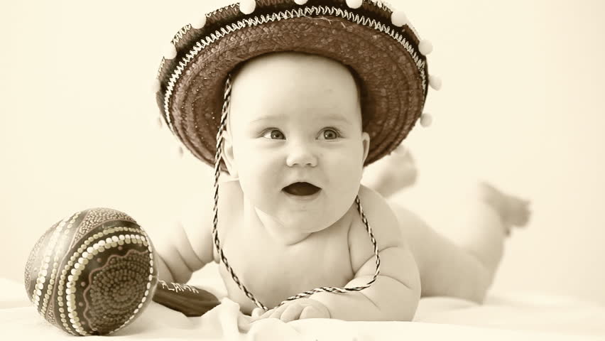 Retro footage: Baby in sombrero hat with maracas on the light background