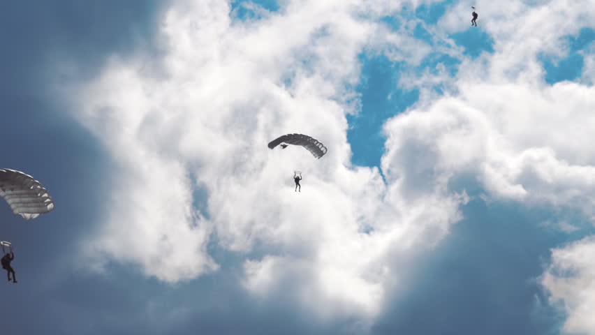 Military parachutists lands on a background of clouds and blue sky