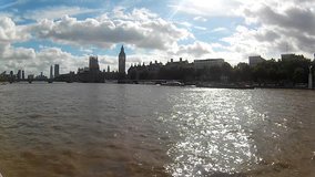 London Big Ben, Westminster bridge, houses of Parliament. River Thames, boat point of view. Sun reflection, cloudy sky footage video.
