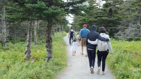 A family hikes on the skyline trail in Cape Breton Nova Scotia Canada at the famous Cabot Trail