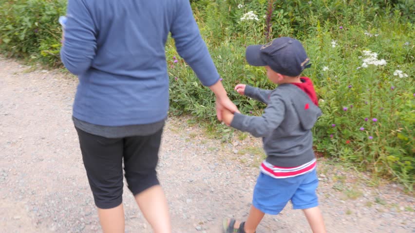 A family hikes on the skyline trail in Cape Breton Nova Scotia Canada at the famous Cabot Trail