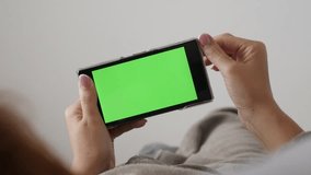 Female  holding green screen smart phone while in bed 4K 2160p 30fps UHD footage - Modern redhead woman with chroma key greenscreen tablet 3840X2160 UltraHD video