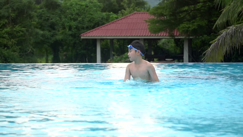 Slow motion of Young Asian boy having fun at pool, happy asian child playing in pool.