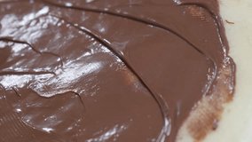 Chocolate topping ready to be rolled on tasty sweet 4K 2160p 30fps UltraHD tilting footage - Hand spreading hazelnut creme over pancake texture close-up 3840X2160 UHD video