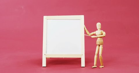 Conceptual image of figurine standing near a chalkboard against red background