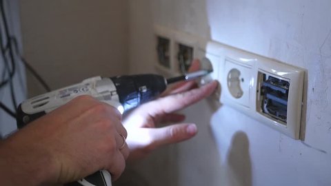 Electrician installs outlet