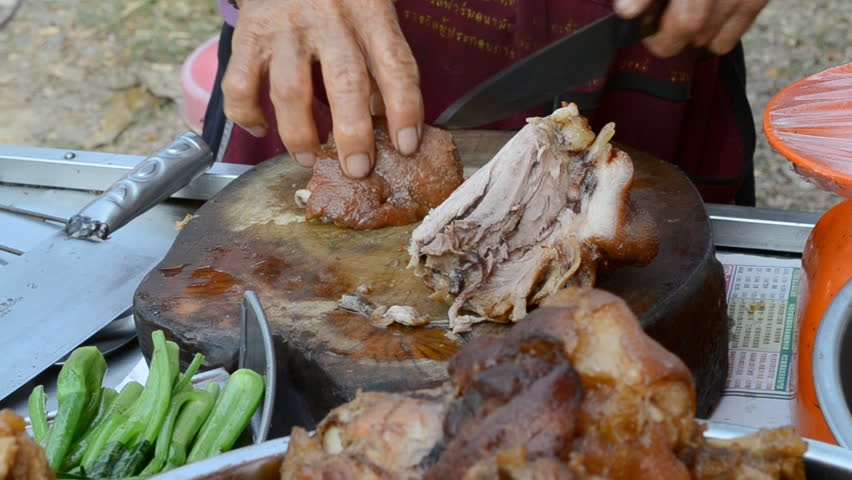 the old man slice steam pork with knife of thailand market