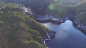 Sideways flight panning along Gordon Dam and Lake, Tasmania, Australia