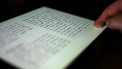 Close-up of a finger turning the pages of a digital ebook reader.  Extreme shallow DOF