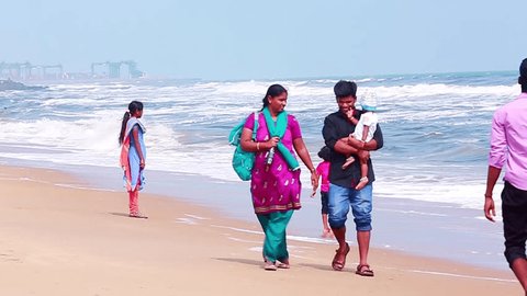 CHENNAI, INDIA - JUNE 14, 2015: Pan shot of tourists enjoying on the beach, Marina Beach,