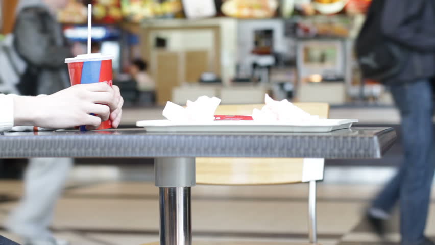 Man holds empty cup at fast-food restaurant