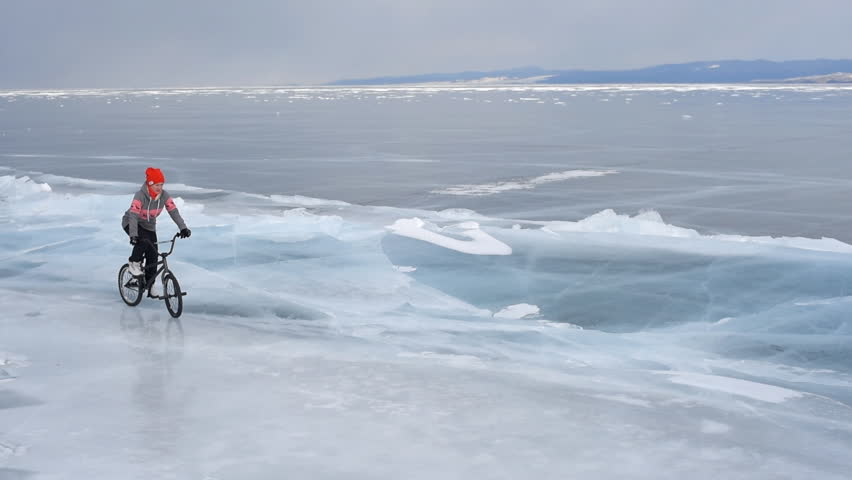 The girl goes on a bike on ice.