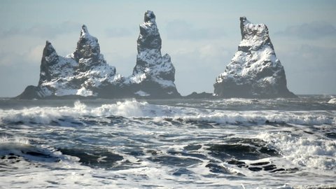 Slowmotion of waves with the three pinnacles at Reynisdrangar cliffs in the background at south coast of Iceland close to Vik at daytime