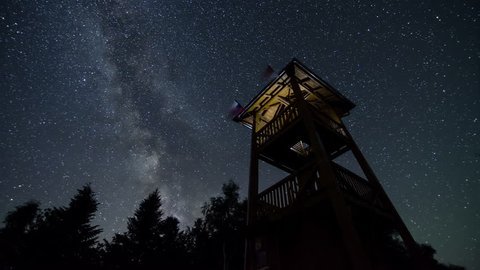 Stars sky with milky way turning over lookout tower time lapse. Astronomy starry night. 4K
