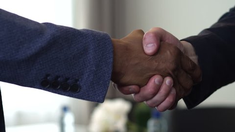We see a handshake between two businessmen. The agreement between them had been reached. One of them is an African American/Handshake of Two Businessman - is the Completion of the Transaction