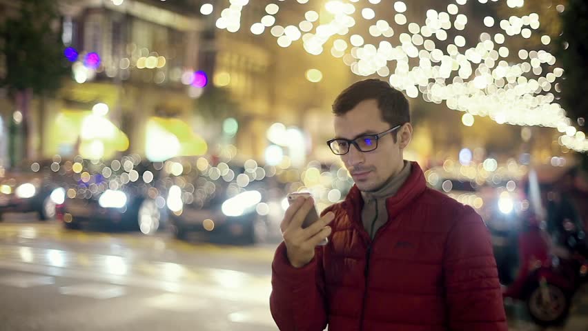 Man Sms Texting Using App on Smart Phone at Night in City