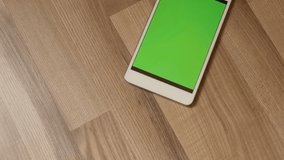 Indoor at home smartphone with greenscreen display 4K 2160p 30fps UltraHD tilting footage - Slow tilt green screen tablet on the wood floor 3840X2160 UHD video