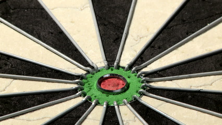 Close up of a dart board from below, three darts with a bull's eye