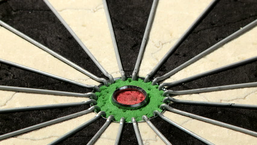Close up shot of a dart board from below, three darts with a bull's eye