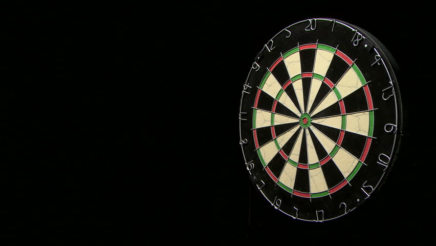 Wide shot of three darts  in a close group along with a bull's eye on a dart