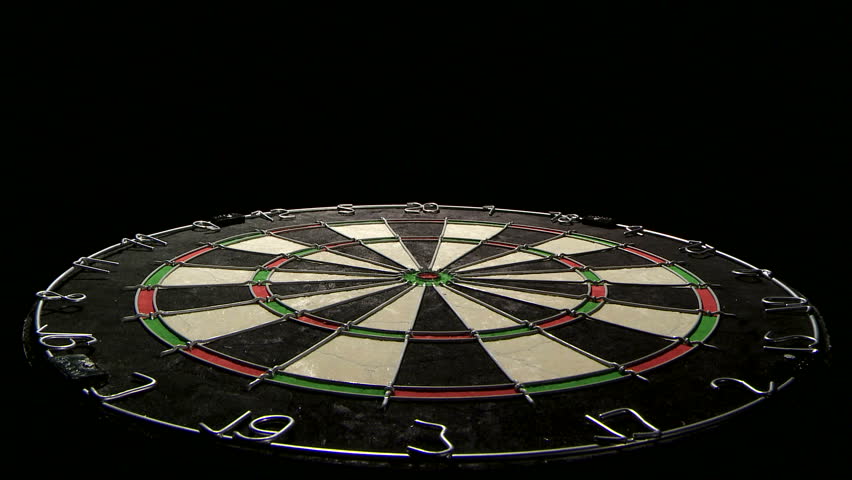Wide shot of a dart board from below, three darts with a bull's eye