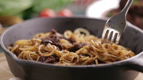 Eating beef and mushroom spaghetti pasta on a cast iron pan