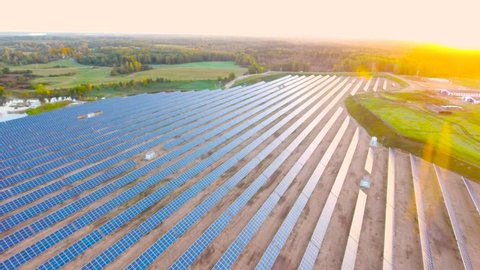 Aerial View. Flying over the solar power plant with sun. Solar panels and sun. Aerial drone shot. 4K 30fps ProRes (HQ)