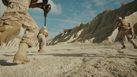 Follow Shot of Squad of Soldiers Running Forward During Military Operation in the Desert. Shot on RED EPIC Cinema Camera in 4K (UHD).