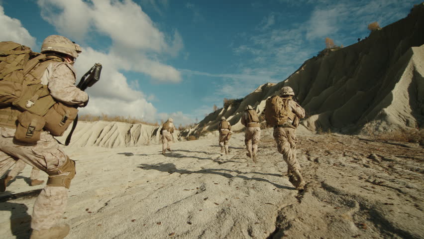 Follow Shot of Squad of Soldiers Running Forward During Military Operation in the Desert. Slow motion. Shot on RED EPIC Cinema Camera in 4K (UHD).