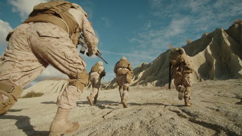 Follow Shot of Squad of Soldiers Running Forward During Military Operation in the Desert. Slow motion. Shot on RED EPIC Cinema Camera in 4K (UHD).