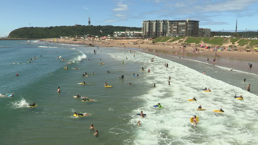 Wide shot of boogie boarders in the sea at Durban, South Africa