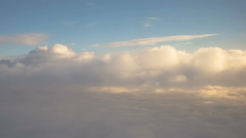 Looking out the window of an airplane as clouds pass by