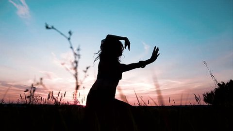 Silhouette of slender girl dance during the sunset.