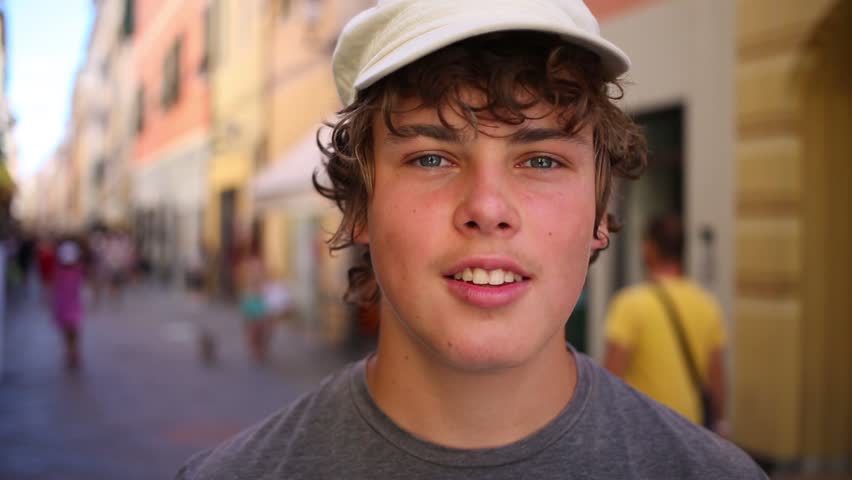 Young smiling man in a white cap on the bright street