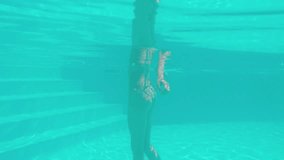 Beautiful woman moving undewater and overwater in swimming pool