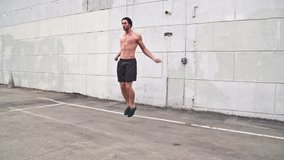 Athletic male working out in an empty parking lot. High-intensity interval training. Slow Motion.