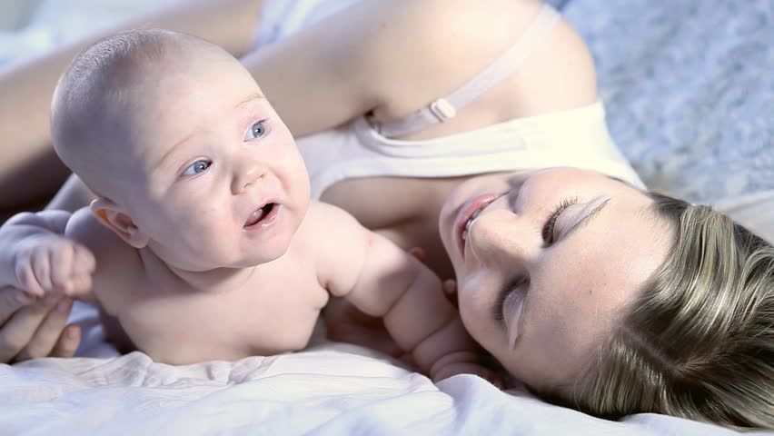 Happy baby and mother on the bed 