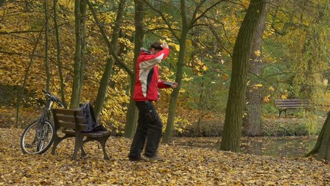 Man in 360Vr Helmet at the Lake in Fall. Young Man in Park at Golden Autumn Landscape is Watching Video 360 Degrees in Virtual Reality Headset, Playing Virtual 360 vr Games in vr Glasses. Bicycle is