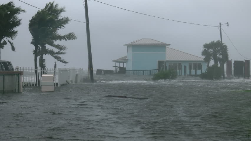 Cocoa Beach, FL/US - October 8, 2016 [4K Hurricane Matthew winds storm surge flooding homes and street with blowing palms and water during peak hurricane winds.]