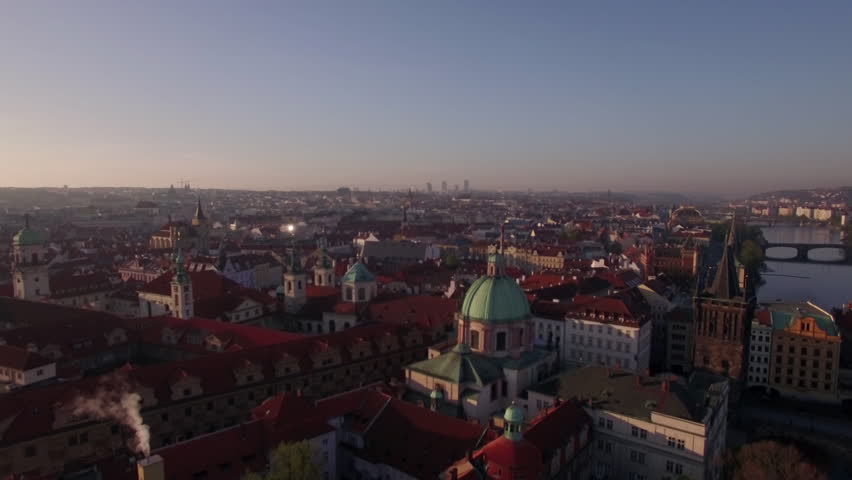 Aerial shot of Prague with its red rooftop architecture, smoke coming out of one of the house chimneys. Czech Republic, Europe