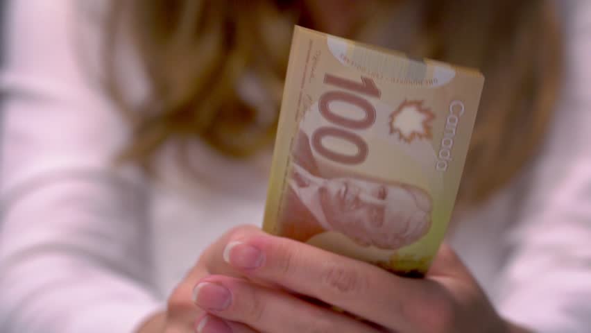 Slow Motion View of a woman Counting Many Canadian 100 bills, polymer plastic type, Woman not happy about not having enough money