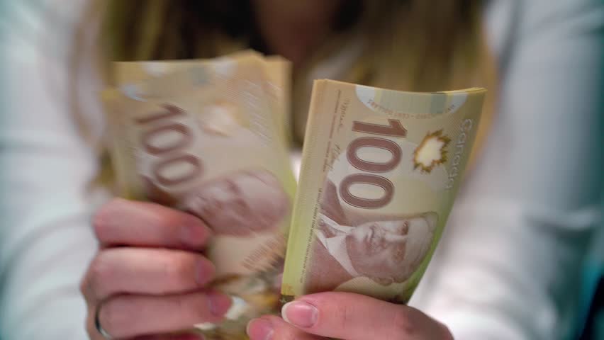 View of a woman Counting Many Canadian 100 bills, polymer plastic type, Woman not happy about not having enough money