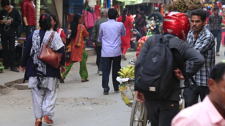 KATHMANDU, NEPAL - OCTOBER 25, 2016 : Unidentified tourists and locals make their way through a busy shopping street in the old city center of Kathmandu, Nepal