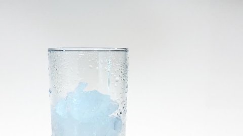 Pouring mineral water into a glass of crushed ice