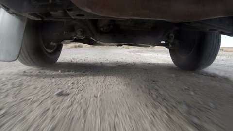 Camera mounted under a truck as it drives off-road.
