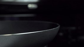 Slow motion shot of an egg being added to a frying pan.