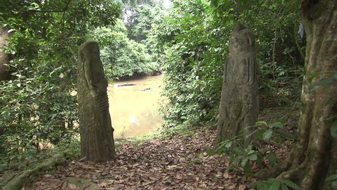 Osogbo, Nigeria - August 2013; Two carved statues stand pillar at Osun River.