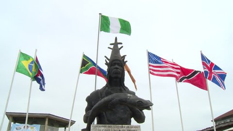 Osogbo, Nigeria - August 2013;Statue of Oba Larooye Gbadewolu, the first Ataoja of Osogbo, with flags of many nations behind.