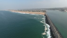 Aerial video above the Newport Beach jetty moving toward the world famous wedge, famous for surfers and body boarders.