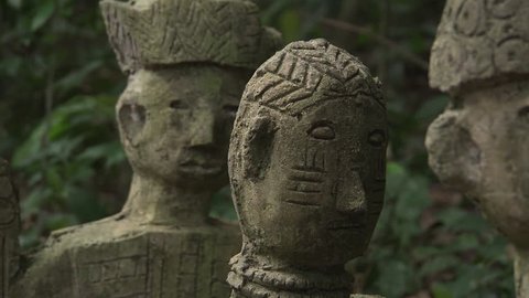 Osogbo, Nigeria - August 2013; CU pan across faces of deity sculptures in Sacred Grove.